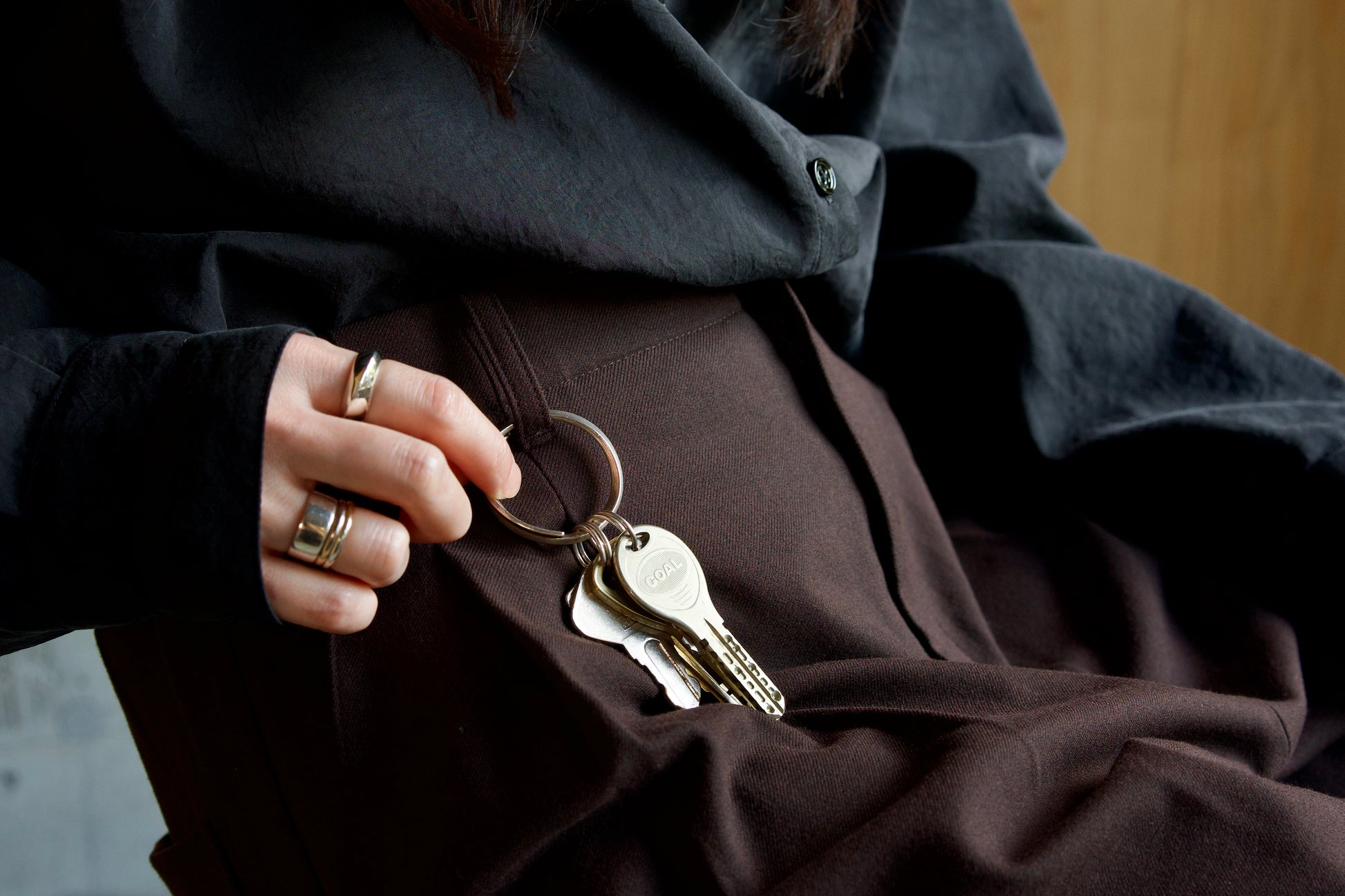 椅子に座った女性のズボンのベルトループに〔004 Silver Key Loop〕が着いている様子のアップ画像