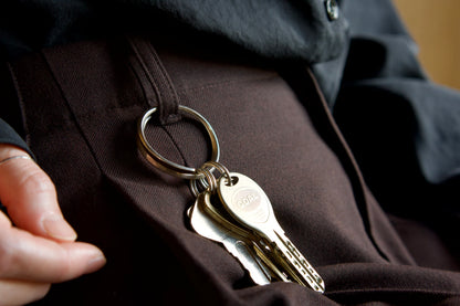 椅子に座った女性のズボンのベルトループに〔004 Silver Key Loop〕が着いている様子のアップ画像